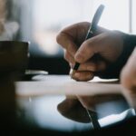 A hand writing with a pen